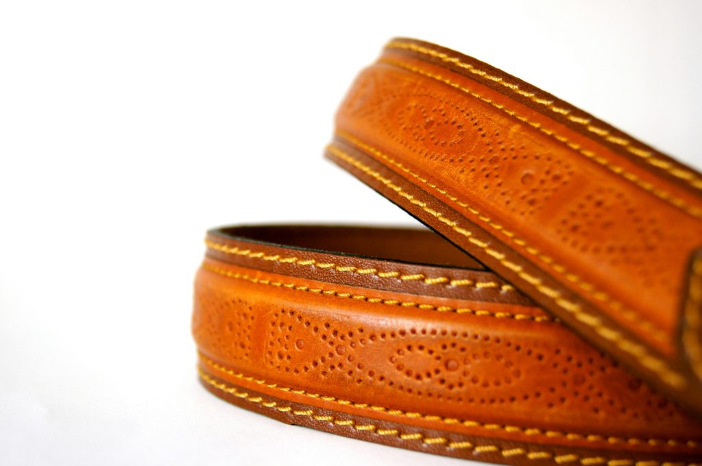 Detailed close-up of a textured brown leather belt showcasing craftsmanship and style.